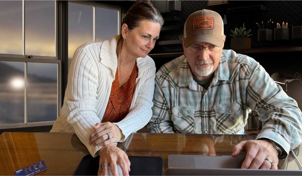 Troy and Suz Hooper reviewing a client financial timeline at their desk